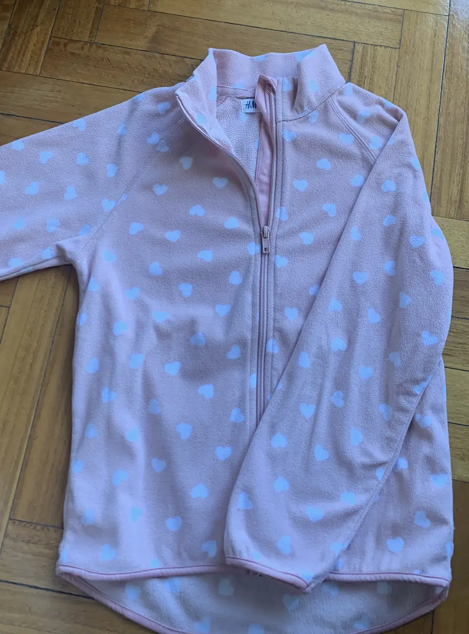 Buzo con cierre de polar rosa con estampado de corazones blancos. Ideal para un look casual y abrigado. Para chiquita entre 4-7 años. 