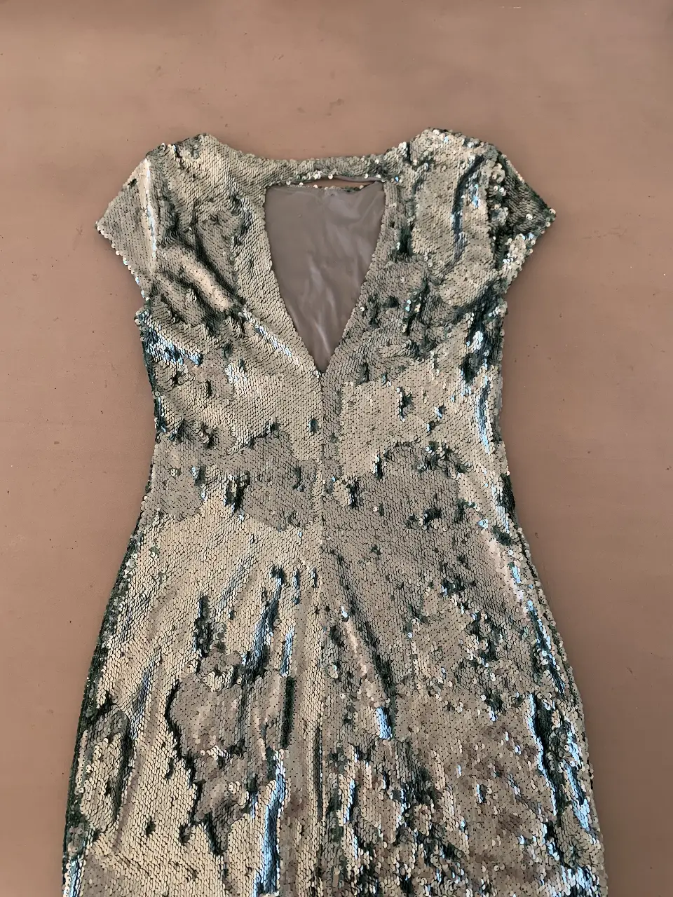 Vestido mini de fiesta con lentejuelas plateadas. Ideal para eventos especiales y salidas nocturnas. Diseño con escote en V y espalda descubierta.