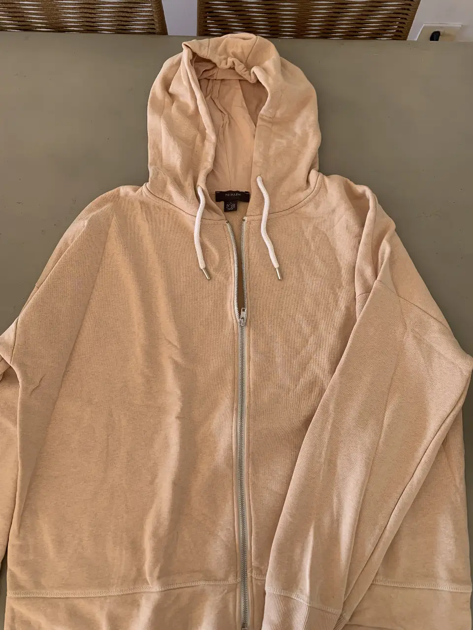 Buzo con cierre y capucha en color crudo. Ideal para un look casual y cómodo.