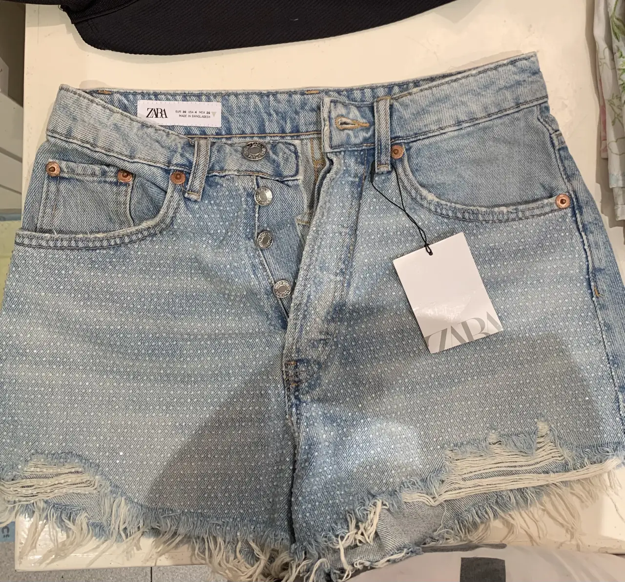 Short de jean de mujer, tiro alto, con roturas y detalles de strass. Ideal para un look casual y canchero.