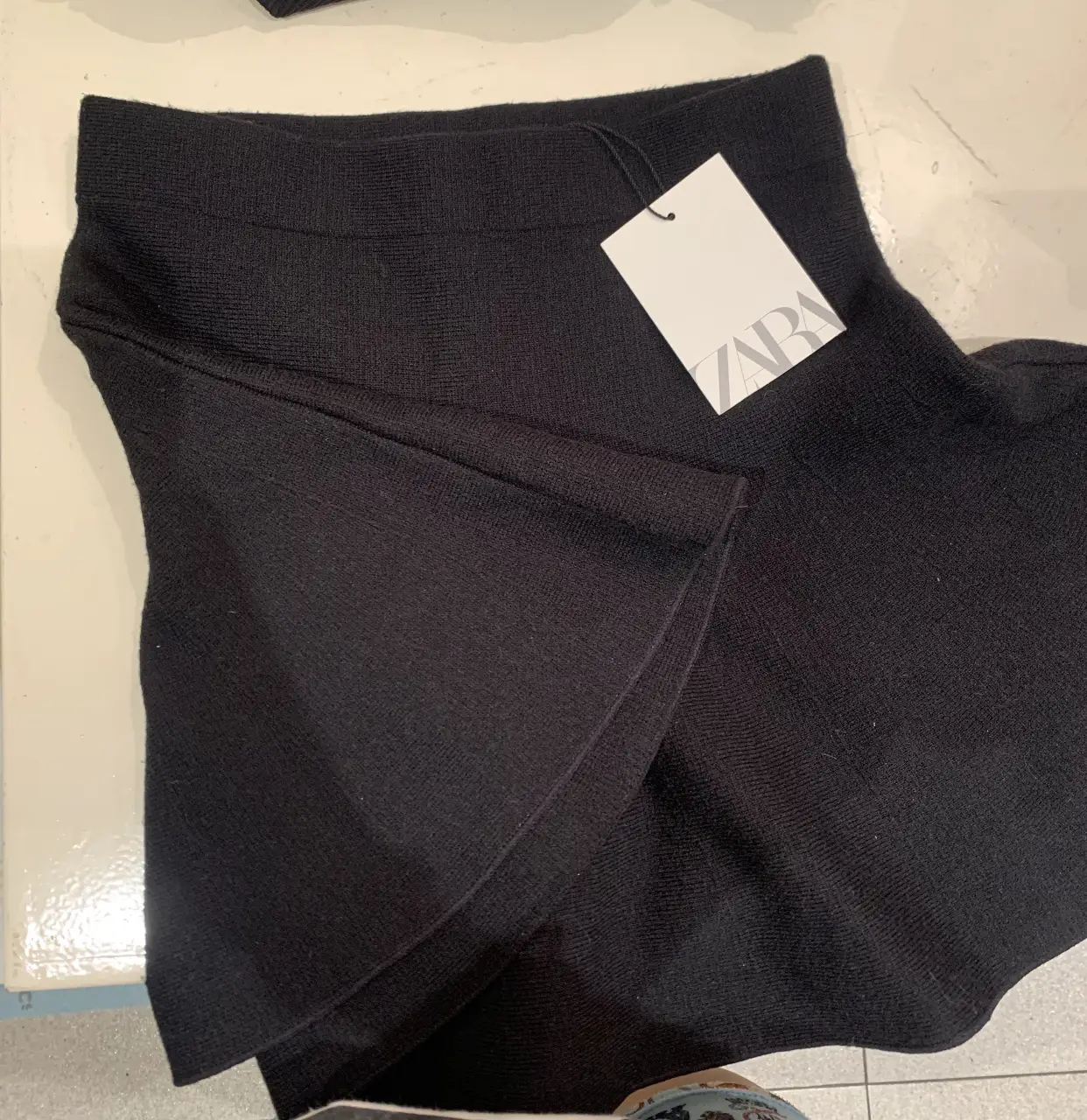 Pollera negra de la marca Zara, con diseño asimétrico y detalle de volado. Ideal para un look elegante y moderno. TALLE S
