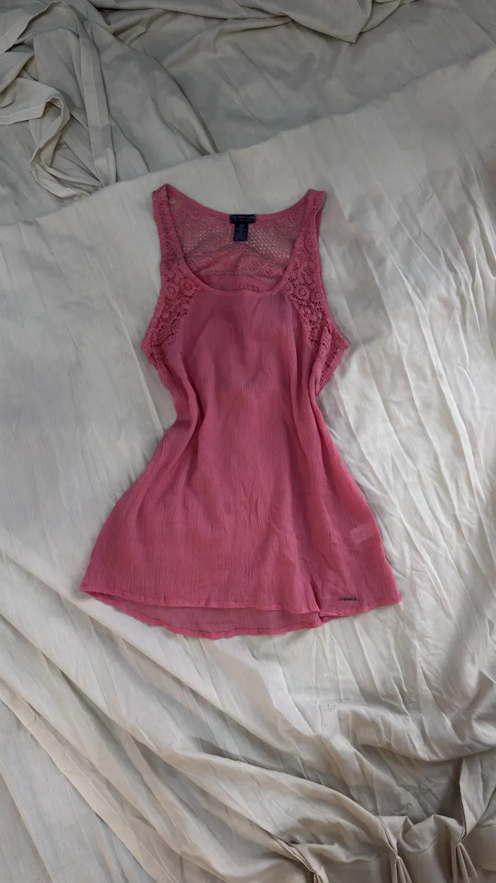 Musculosa rosa con detalles de encaje en la espalda y breteles. Ideal para un look fresco y femenino.