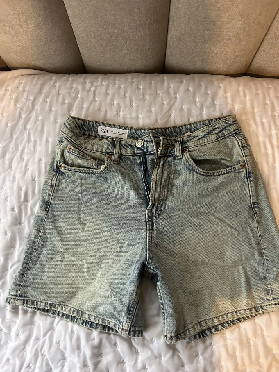 Shorts de jean tiro alto con roturas y lavado claro.