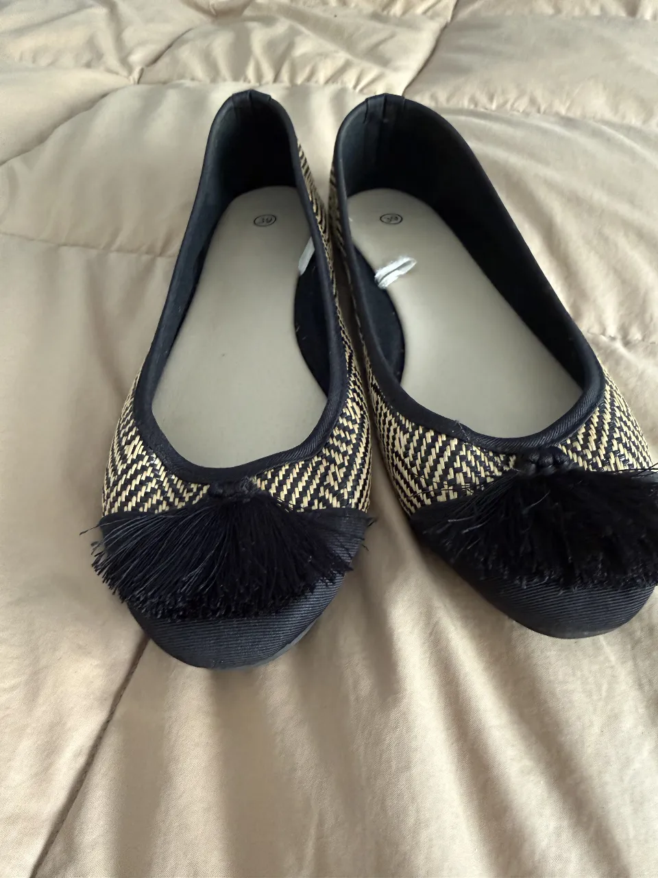 Bellísimas ballerinas con un diseño tejido en espiga en tonos crudo y negro (tipo rafia). Tienen un detalle de pompones negros en la punta que les da un toque chic y moderno. Ideales para complementar looks casuales y darle un toque de estilo a tu día a día. Importadas