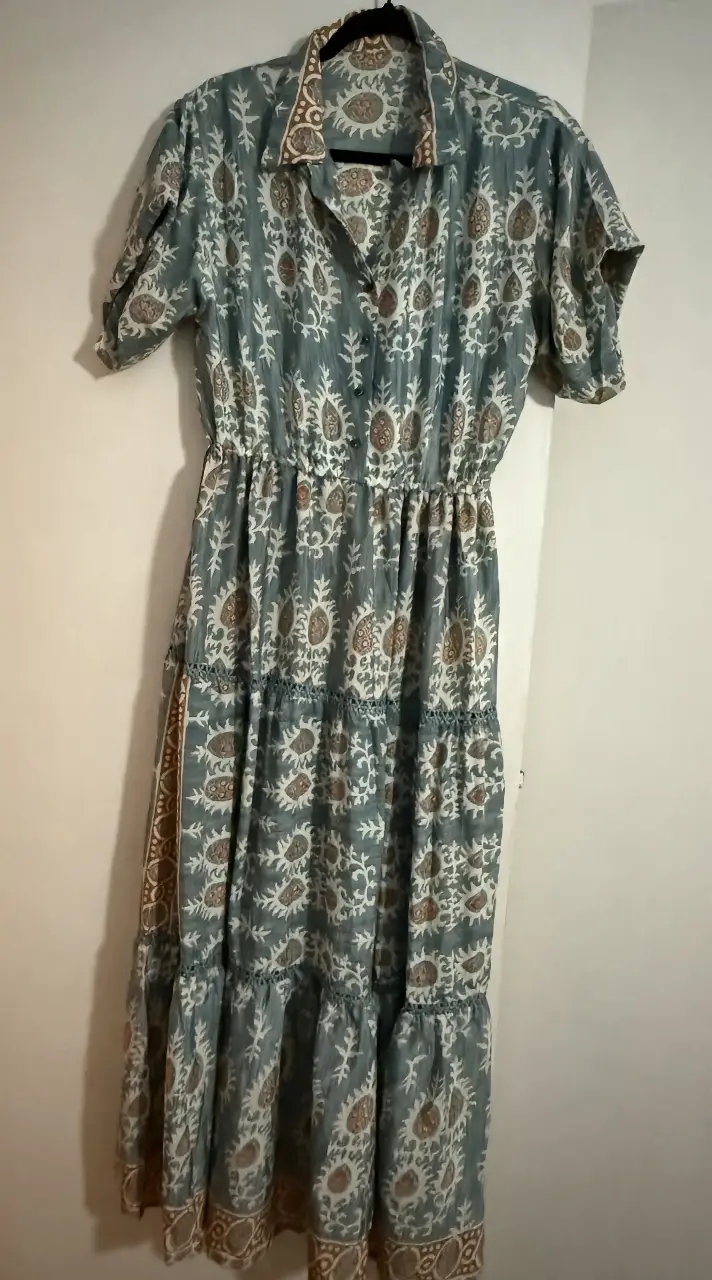 Vestido  largo  estampado con mangas cortas y cintura elastizada. Diseño con estampado floral en tonos azules y ocres. Ideal para un look casual y fresco.