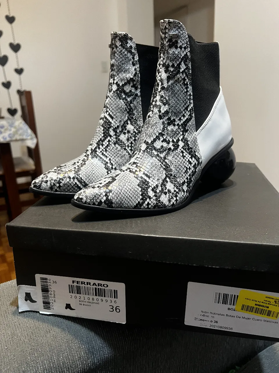 Botines de mujer con estampado de serpiente en blanco y negro. Diseño moderno con detalles en blanco y negro, y un taco esférico. Ideales para un look sofisticado y a la moda.