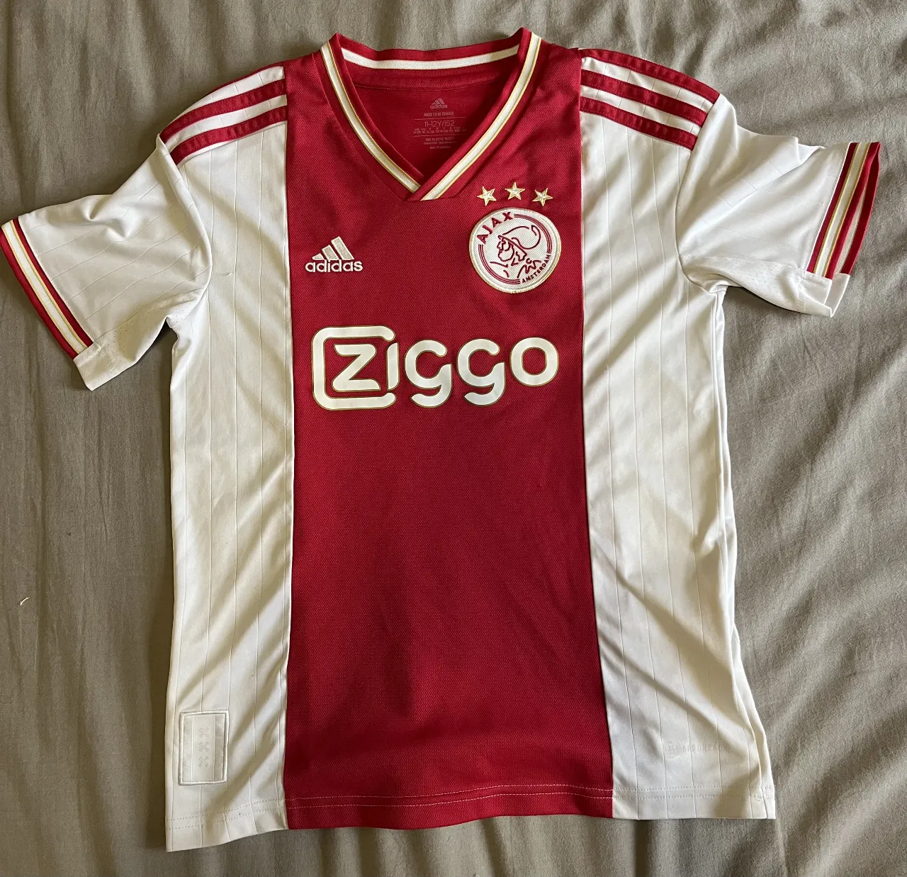 Camiseta de fútbol del Ajax, con el diseño clásico en rojo y blanco. Ideal para fanáticos y coleccionistas.