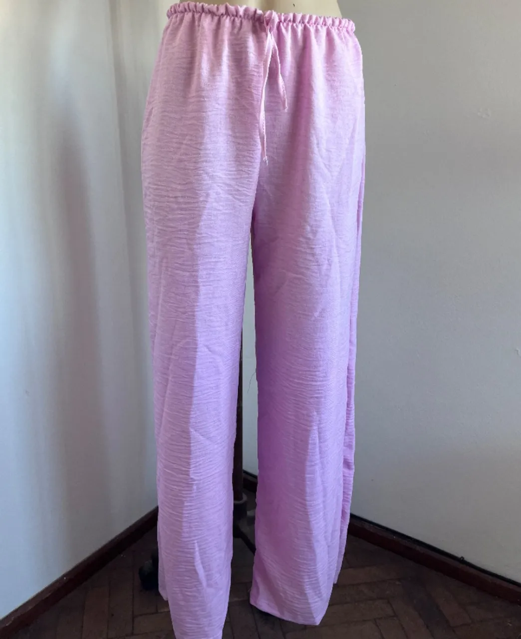 Pantalón de lino color rosa, tiro alto con cintura elastizada y cordón ajustable. Corte ancho y relajado, ideal para un look cómodo y fresco. nuevo. talle único. medidas cintura 34 a 46. cadera 65 largo 100.