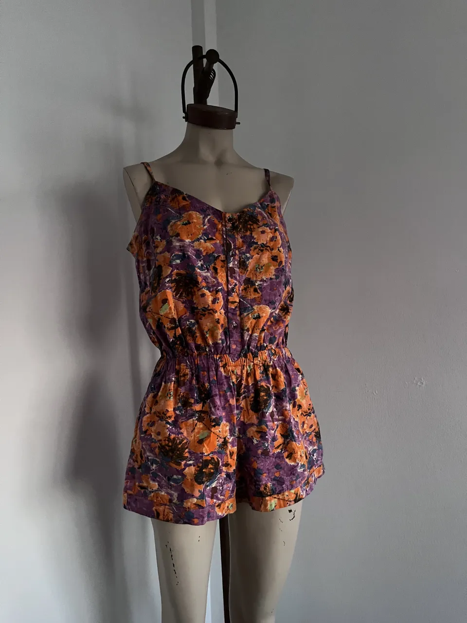 Mono corto estampado floral con tiras finas y botones en el frente. Cintura elastizada. como nuevo. 100% algodón. medidas 78 cm largo 60 cm cadera 35-45 cm cintura 50 cm sisa.