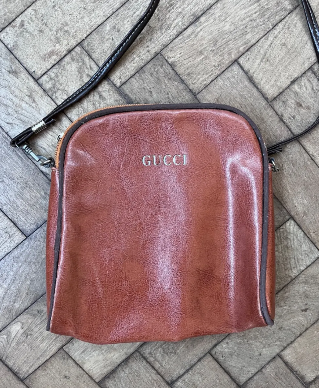 Bolso de cuero marrón con logo. Ideal para llevar lo esencial con estilo. usada. buen estado en general. tiene algunos detalles en los bordes, como se puede observar en fotos, y la hebilla del cierre está rota pero el cierre funciona sin problemas. medidas 20 x 20 + 46 de correa.