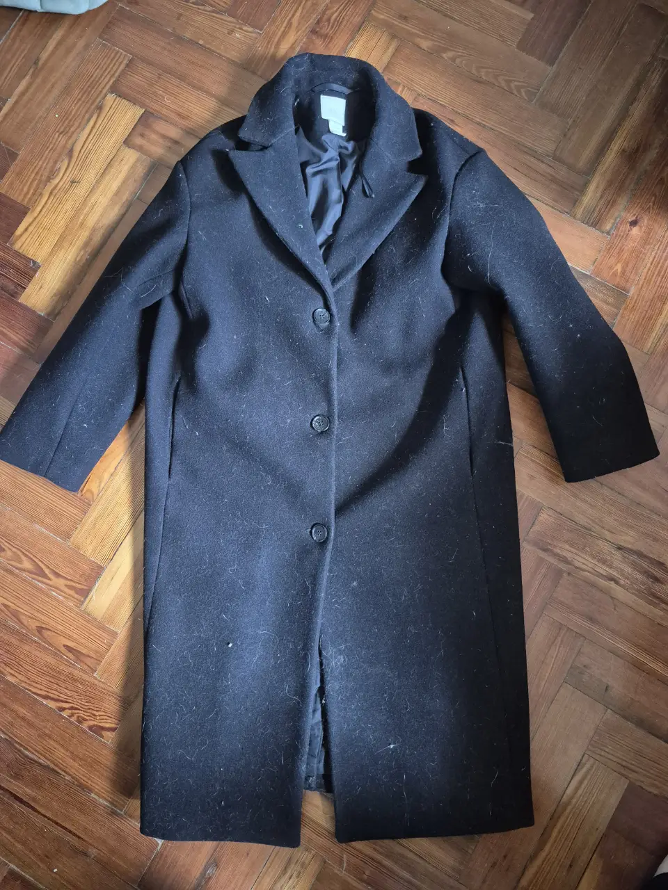 Sobretodo negro de paño, con tres botones al frente y solapas clásicas. Ideal para un look elegante y abrigado.