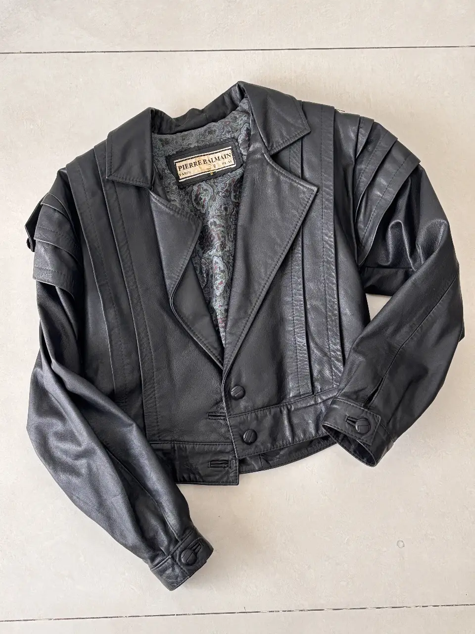 Chaqueta de cuero Pierre Balmain vintage para mujer. Diseño biker con detalles en los hombros y botones. Ideal para un look retro y sofisticado. Cuero Vacuno 100%
