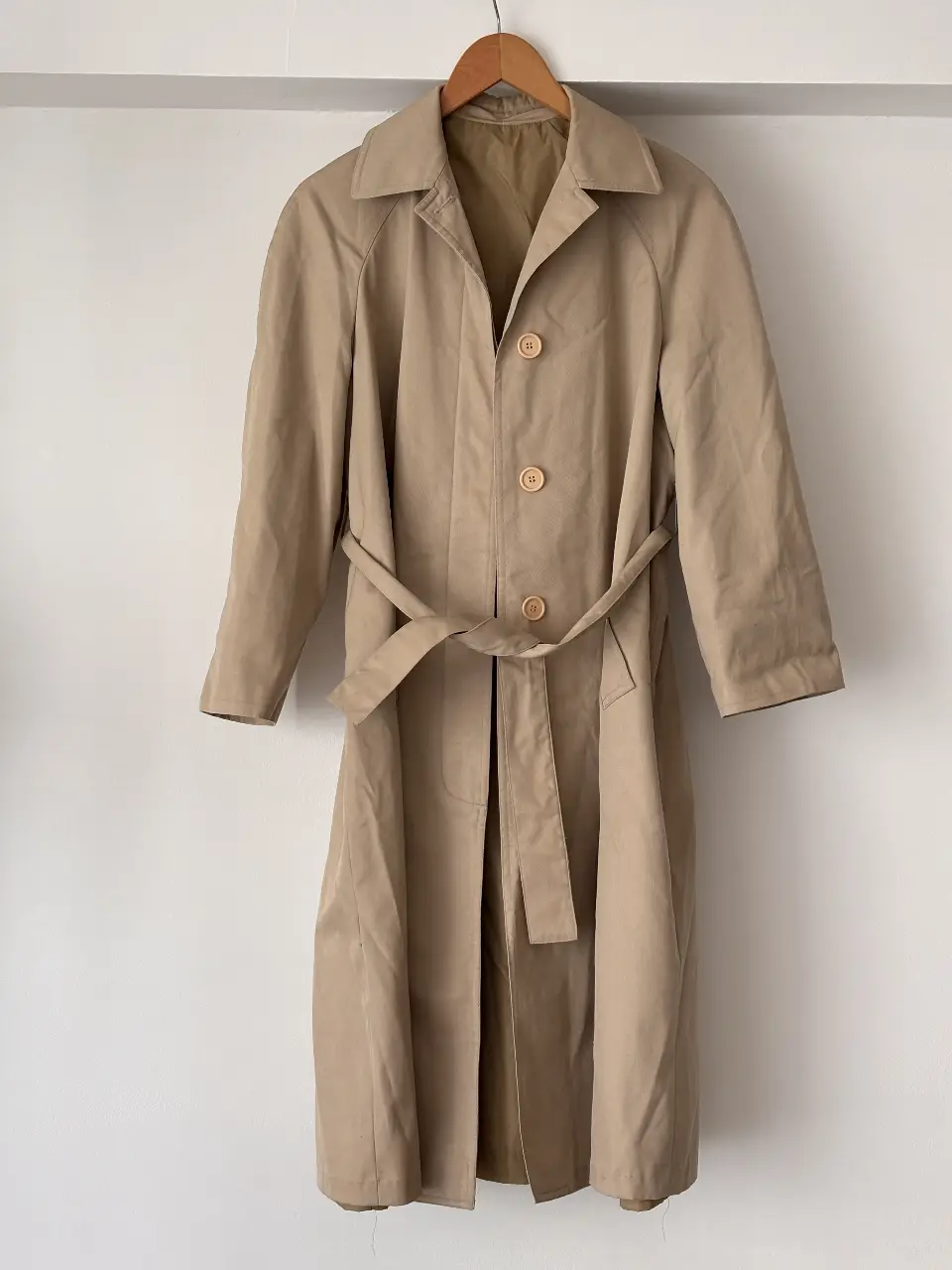 Trench coat clásico en color khaki, ideal para un look elegante y atemporal. Con cinturón para ajustar la cintura y botones a tono. Perfecto para la temporada de otoño e invierno.