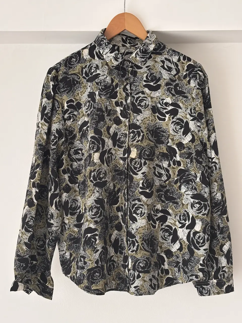 Camisa estampada con diseño de rosas en tonos negro y verde. Ideal para un look vintage y con estilo.