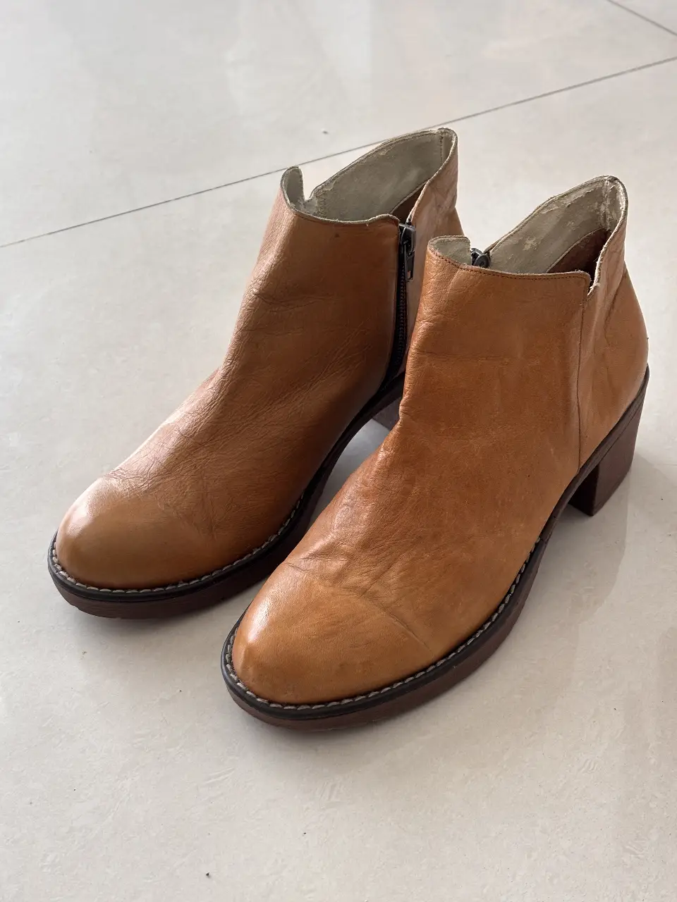 Botineras color suela de cuero vacuno en su exterior, ideales para un look casual y cómodo. Diseño clásico con cierre lateral y suela resistente. El interior presenta desgaste ya que es de cuero sintético 