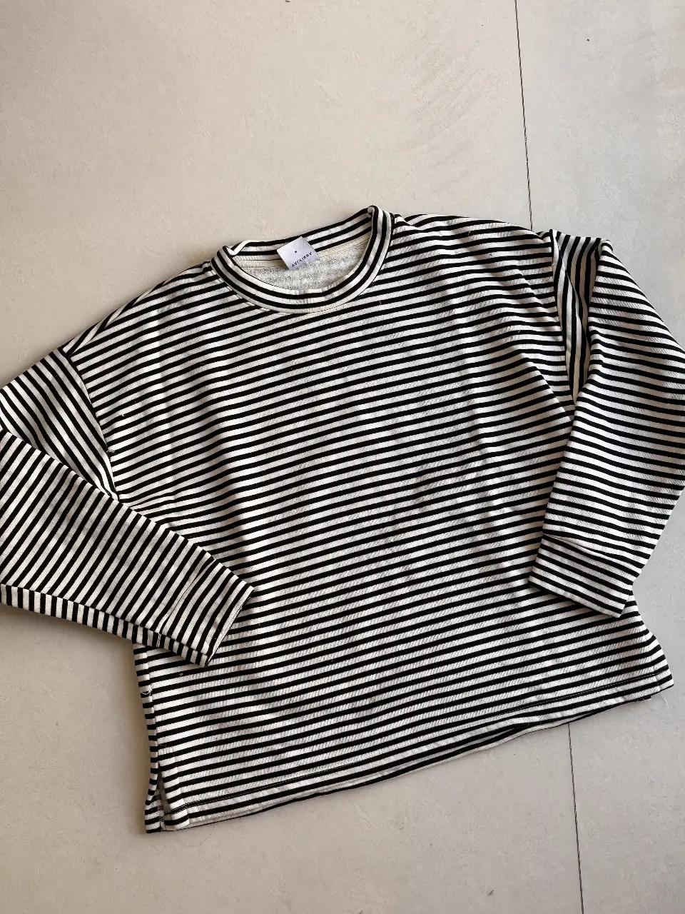 Sweater a rayas blanco y negro, de cuello redondo, manga larga. Ideal para un look casual y cómodo.