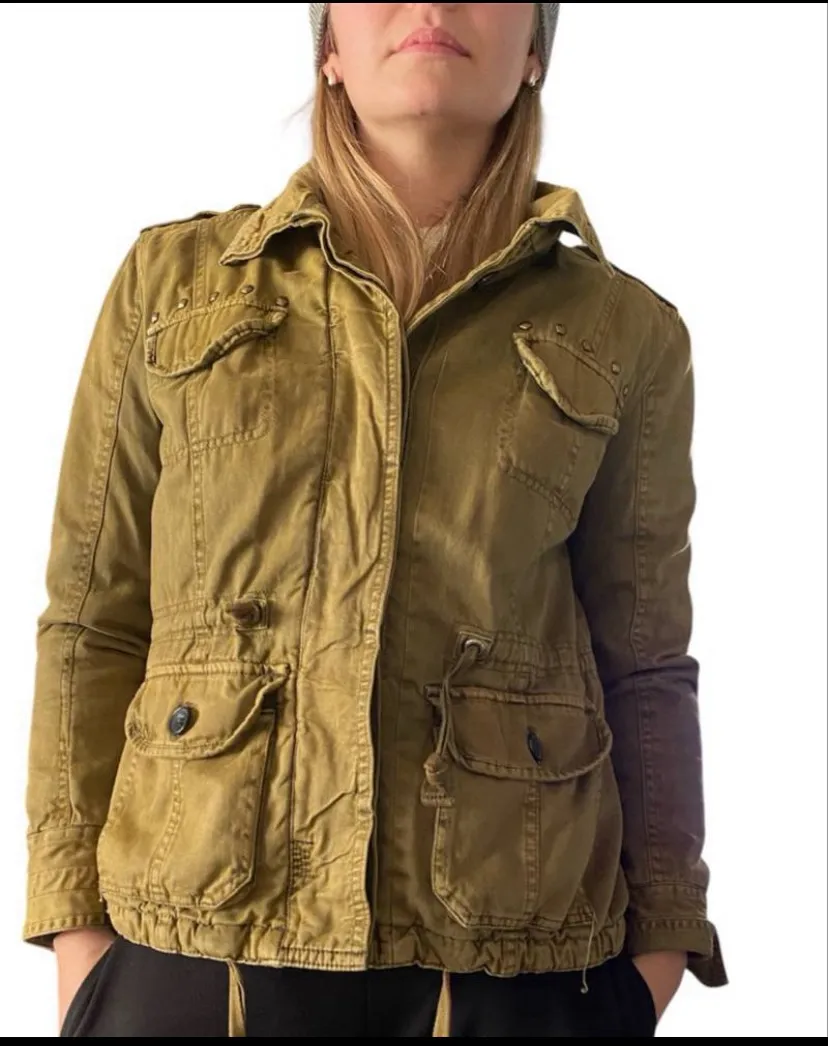 

campera rapsodia verde. talle m. modelo azalea gabardina. algodón y poliéster.
peluche interior. cierre con botones.
hombros 47cm. axilas 58cm. sisa 24cm. mangas 62cm. cintura regulable 51cm.
cadera 55cm. largo 63cm. impecablePosee bolsillos frontales con tapa y botones, cuello camisero y ajuste de cintura con cordón interno. Cierre principal con botones a la vista.