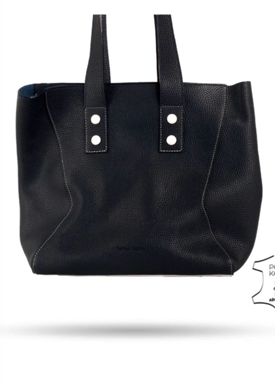 Bolso tote negro de cuero Peter Kent, con detalles de costura en blanco y un pequeño bolsillo con cierre. Incluye un sobre con el logo de la marca.