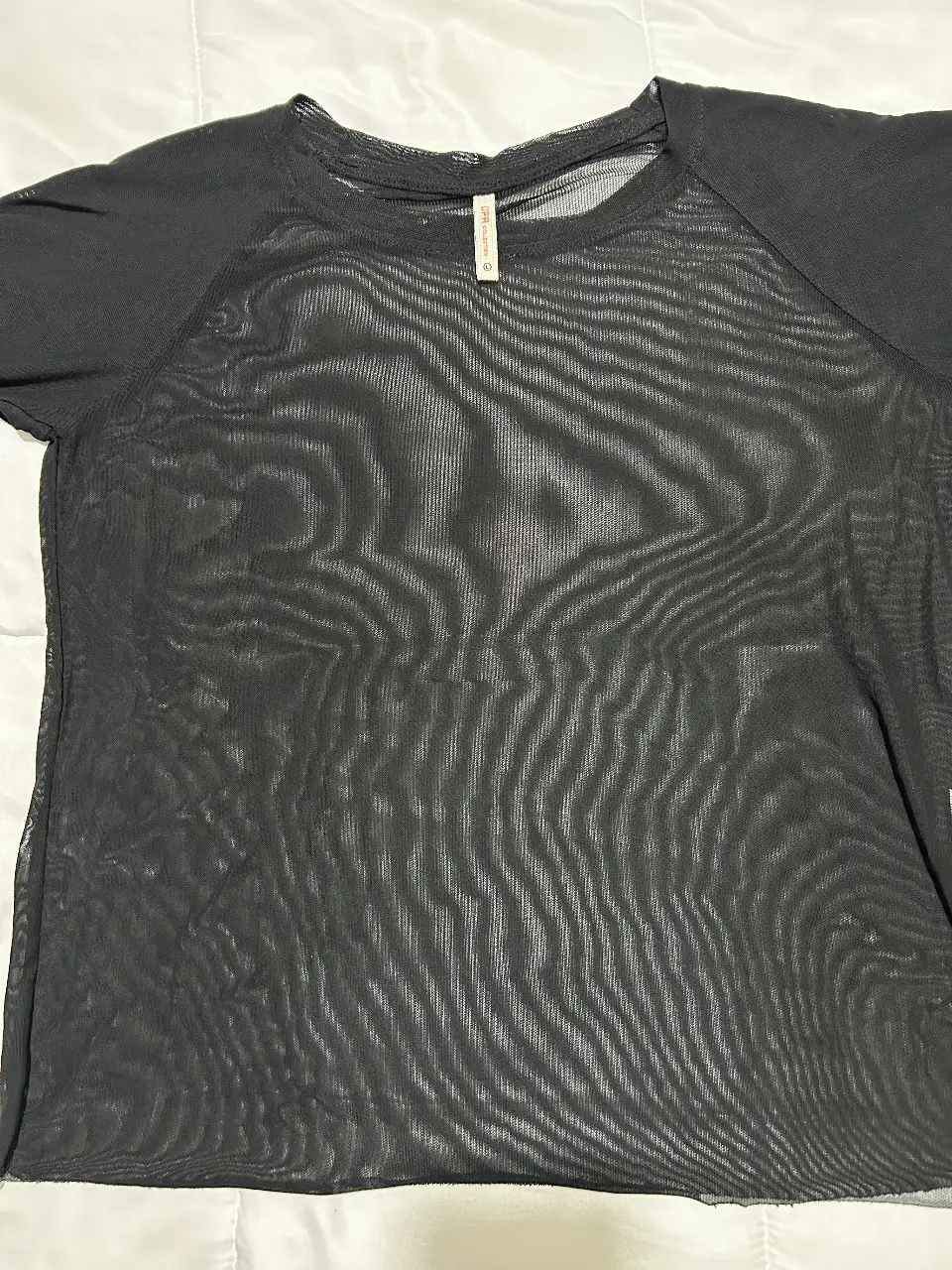 Remera de red negra, ideal para usar sobre otra prenda. Perfecta para un look moderno y audaz.
