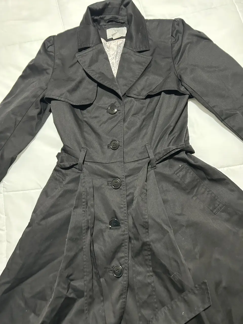 Trench coat negro de H&M, talle 4 (EUR). Ideal para un look elegante y sofisticado. Confeccionado en material resistente y diseño clásico.