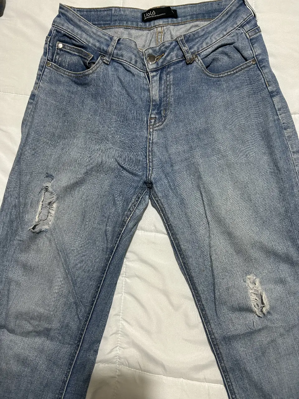 Jeans de mujer, tiro medio, con roturas en las rodillas. Un clásico para un look casual y moderno.