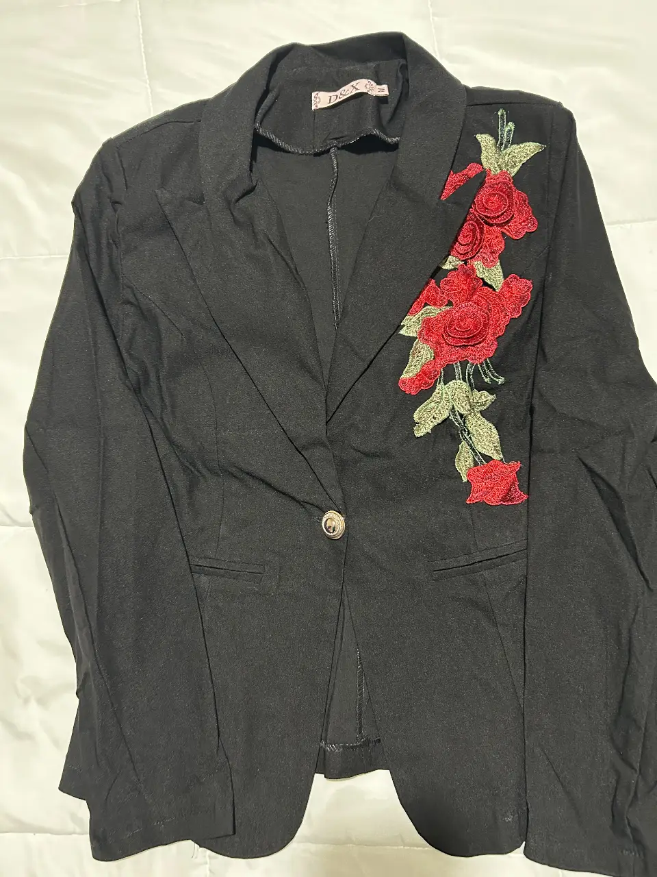 Elegante blazer negro de mujer con detalle de bordado floral en rojo. Ideal para un look sofisticado y con estilo.