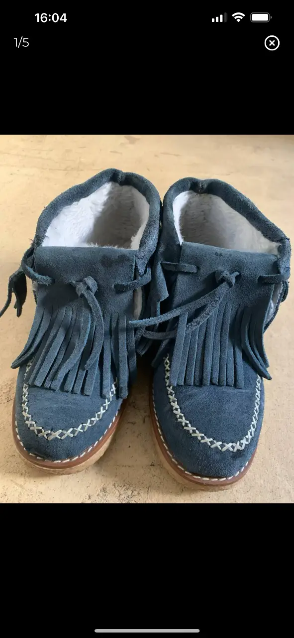 Botines de gamuza azul con flecos y forro de piel. Ideales para un look casual y cómodo.