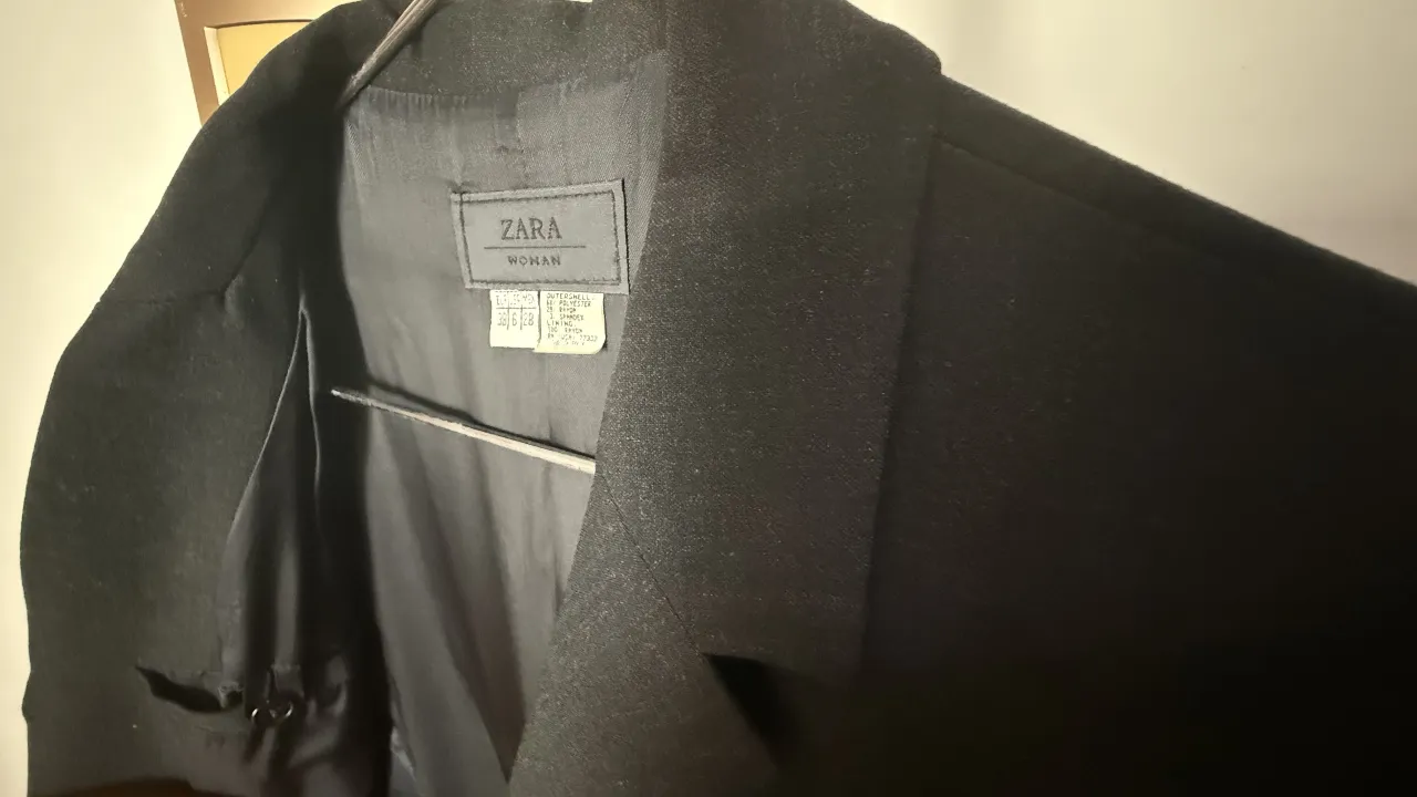 Elegante blazer negro de Zara Woman, ideal para un look formal o de trabajo. Confeccionado en una mezcla de poliéster y rayón, este blazer ofrece un ajuste clásico y sofisticado. Perfecto para combinar con pantalones sastreros o faldas.