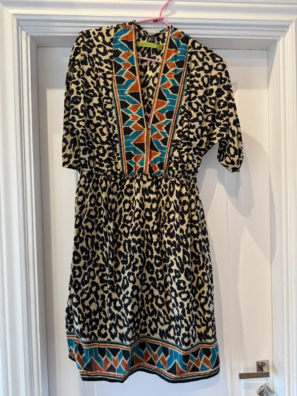 Vestido midi con estampado de leopardo y detalles étnicos en el cuello y cintura. Ideal para un look casual con un toque bohemio.