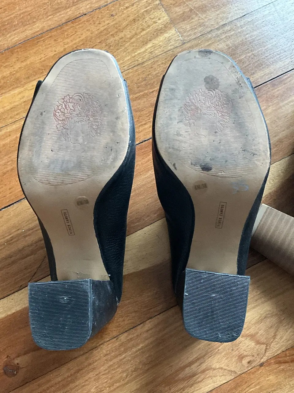 Tacos negros de cuero, con taco ancho y diseño peep toe. Marca Vince Camuto.