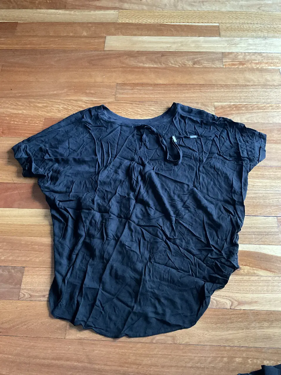 Blusa negra de tela liviana, con detalle de abertura en la espalda y lazo para atar en el cuello. Ideal para un look casual y fresco.