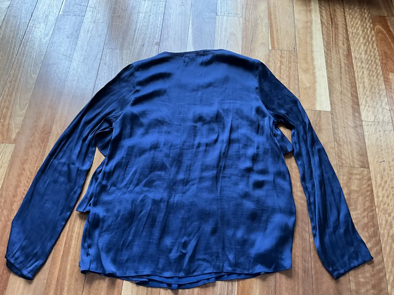 Blusa de mujer azul marino de seda, con mangas largas y detalles de volantes. Ideal para un look elegante y sofisticado.