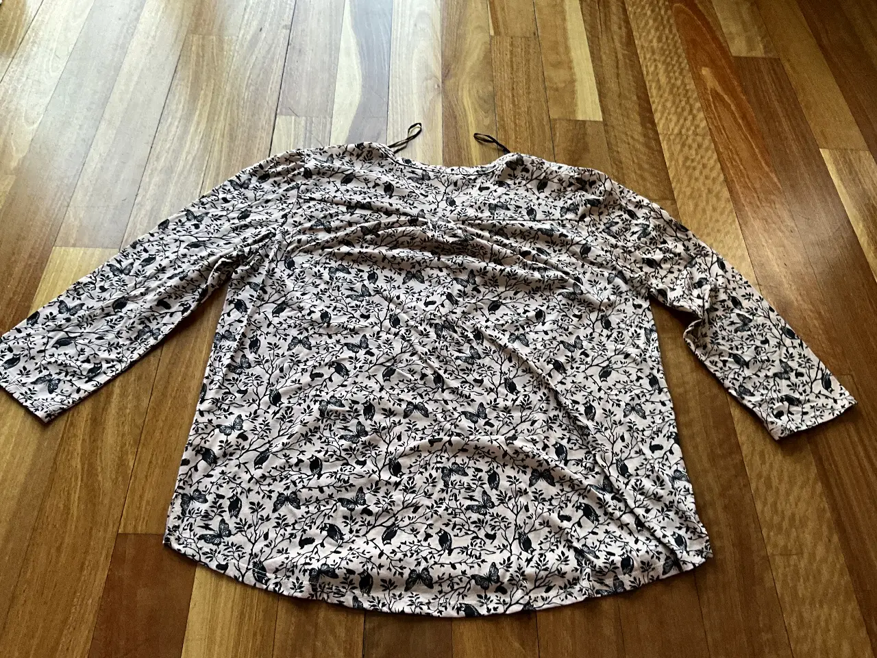 Blusa de manga larga con estampado floral en tonos rosa y negro. Ideal para un look casual y femenino.