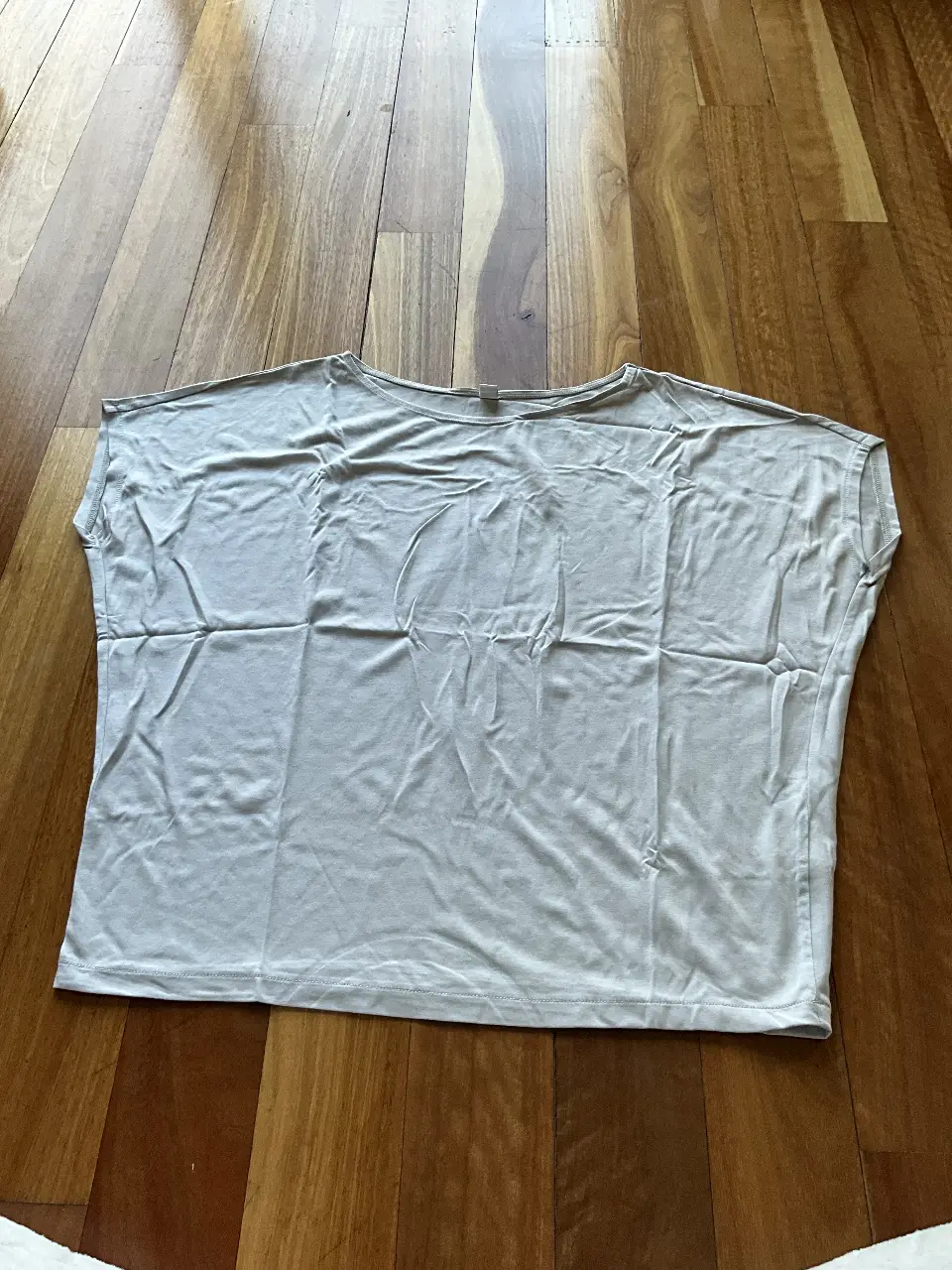 Remera de manga corta de color gris claro, de la marca Uniqlo, ideal para un look casual y cómodo. Talle XS, hecha en Vietnam.