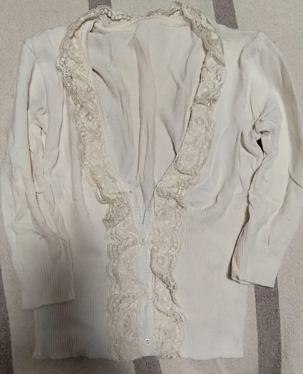 Cardigan blanco con detalles de encaje en el frente. Ideal para un look romántico y elegante.