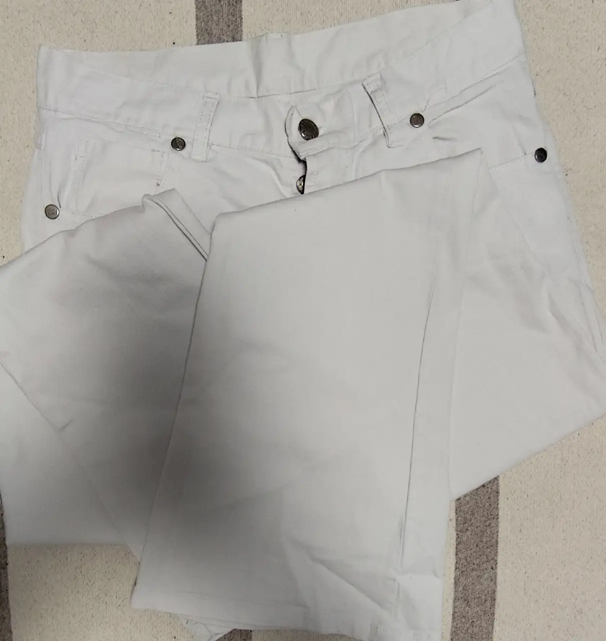 Jeans oxford blancos tiro bajo para mujer, ideales para un look casual y moderno. Confeccionados en tela resistente y diseño clásico de cinco bolsillos.
