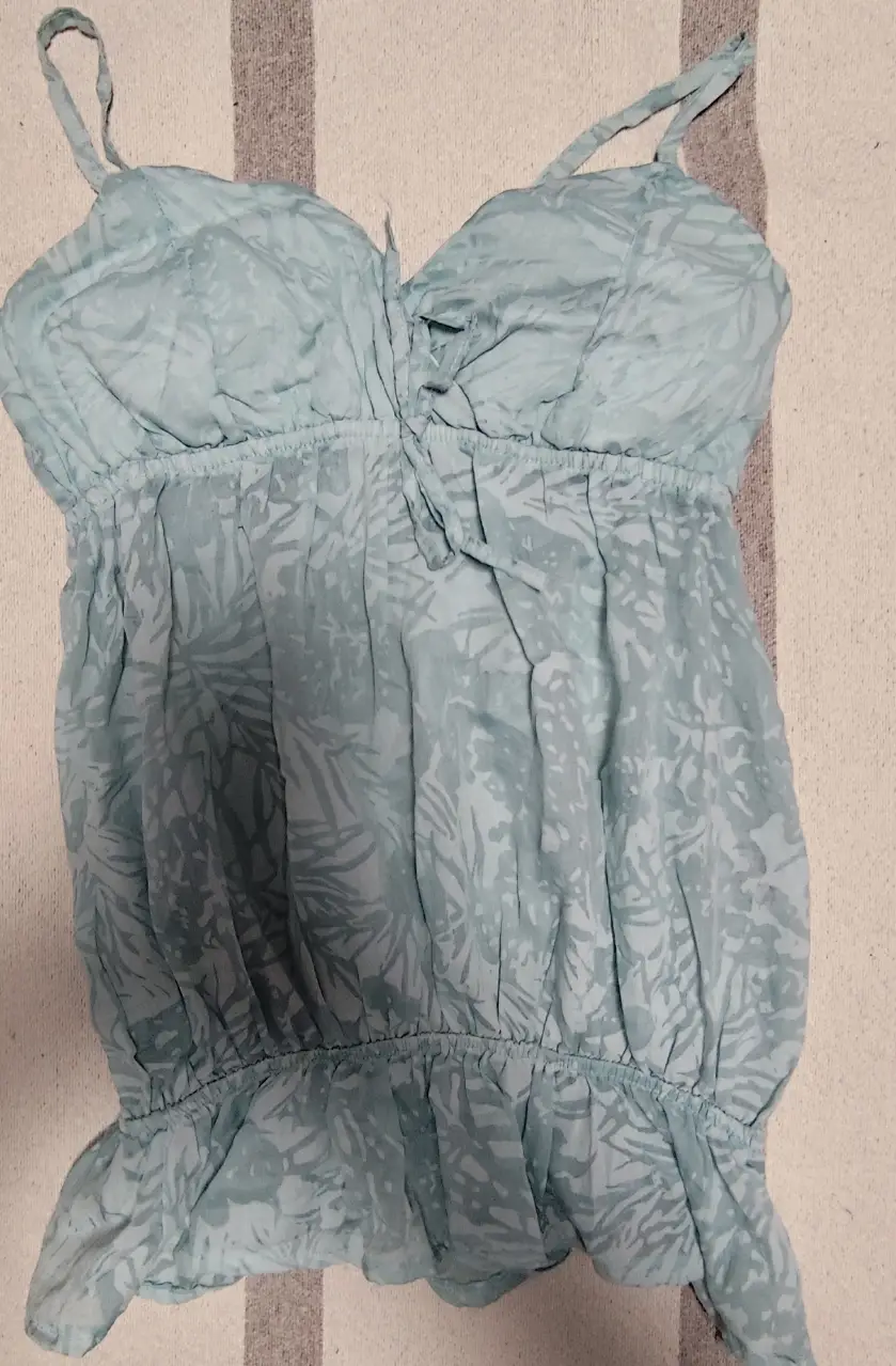 Top celeste con estampado floral, ideal para el verano. Diseño con tirantes finos y detalle de lazo en el frente. Perfecto para un look fresco y casual.