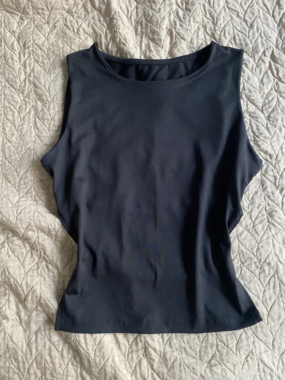 Top negro, ideal para un look casual. Diseño moderno con espalda descubierta y ajuste regulable.