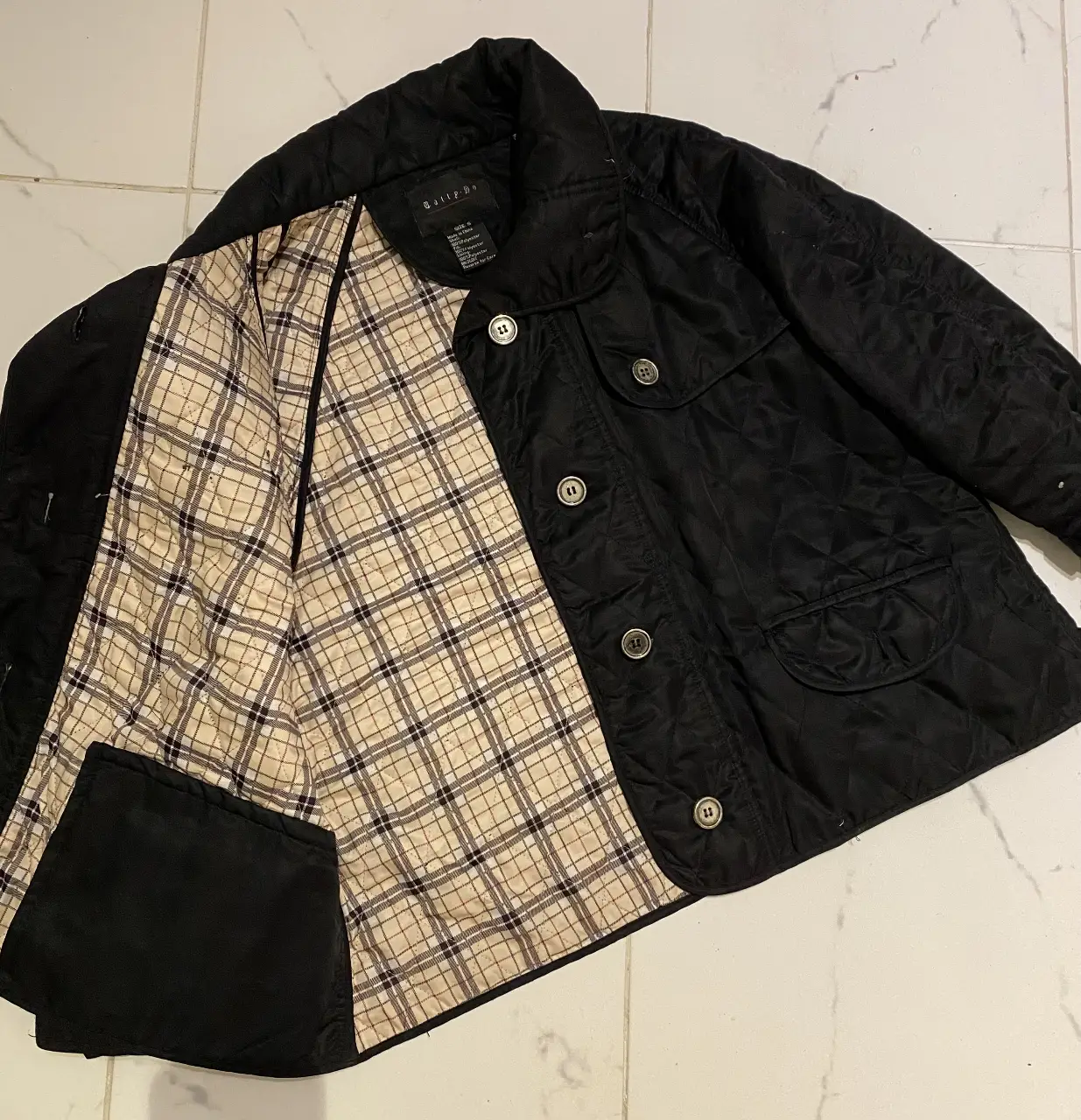 Campera negra acolchada de la marca "Bailey's". Posee forro interior a cuadros, dos bolsillos delanteros y botones para cerrar. Ideal para el invierno. es talle s pero va para un M. importada