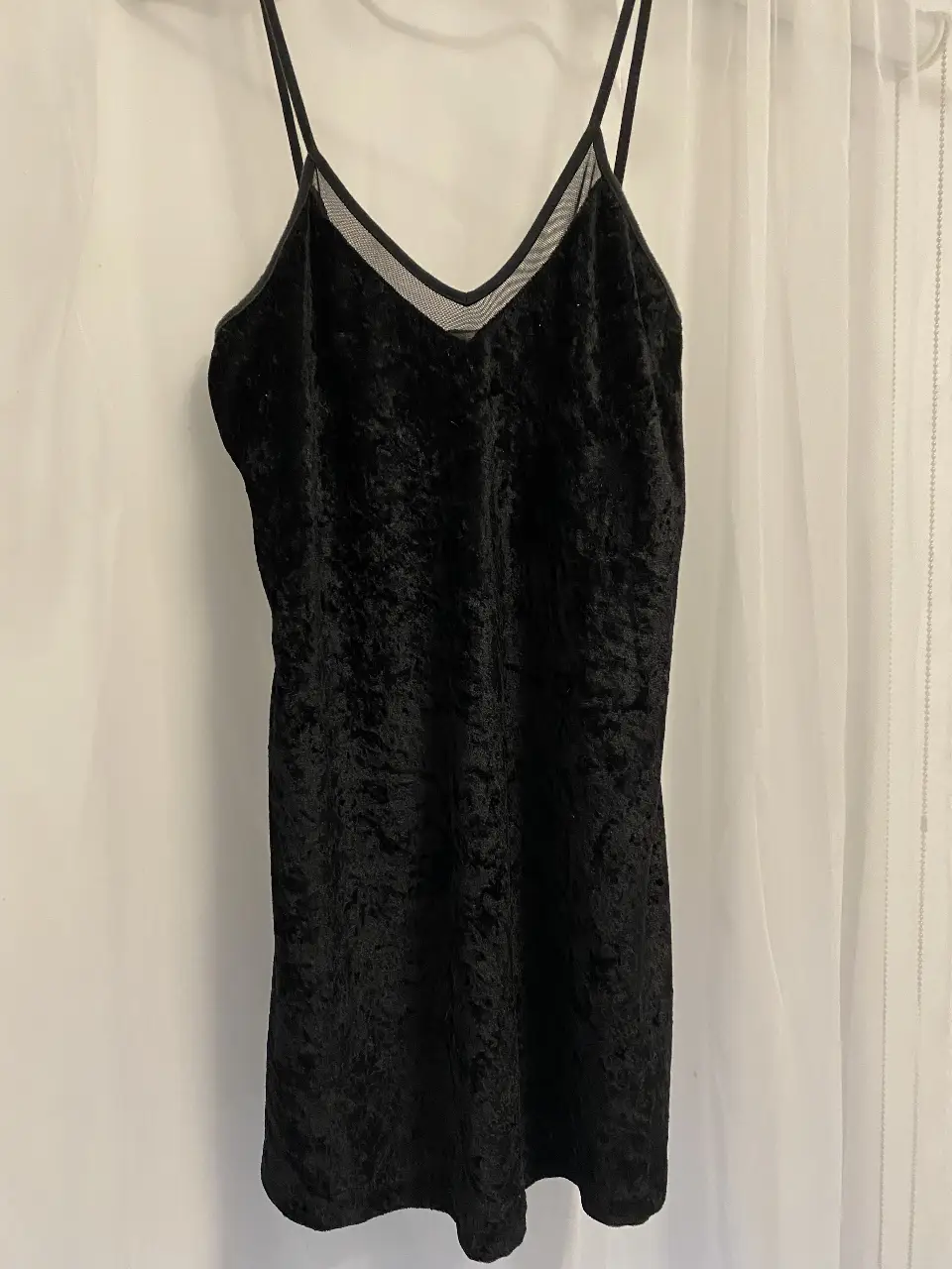 Top negro de terciopelo con detalle de mesh en el escote. Ideal para una salida o fiesta.