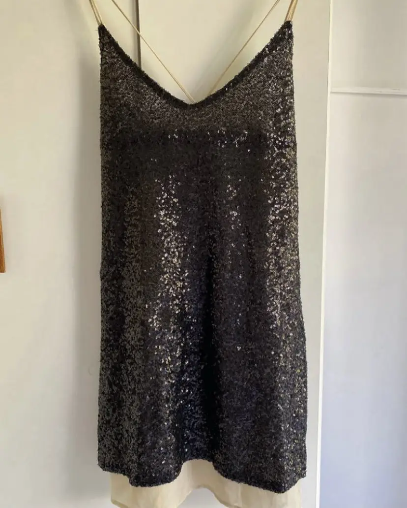 Vestido de fiesta con lentejuelas negras. Ideal para eventos nocturnos y celebraciones. Diseño con tirantes finos y espalda descubierta.