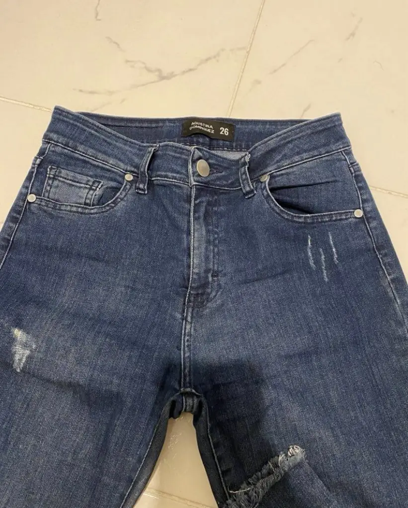 Jeans de mujer, tiro medio, corte recto, con detalles de roturas y desflecado en el bajo. Marca Agustina Dominguez, talle 26.