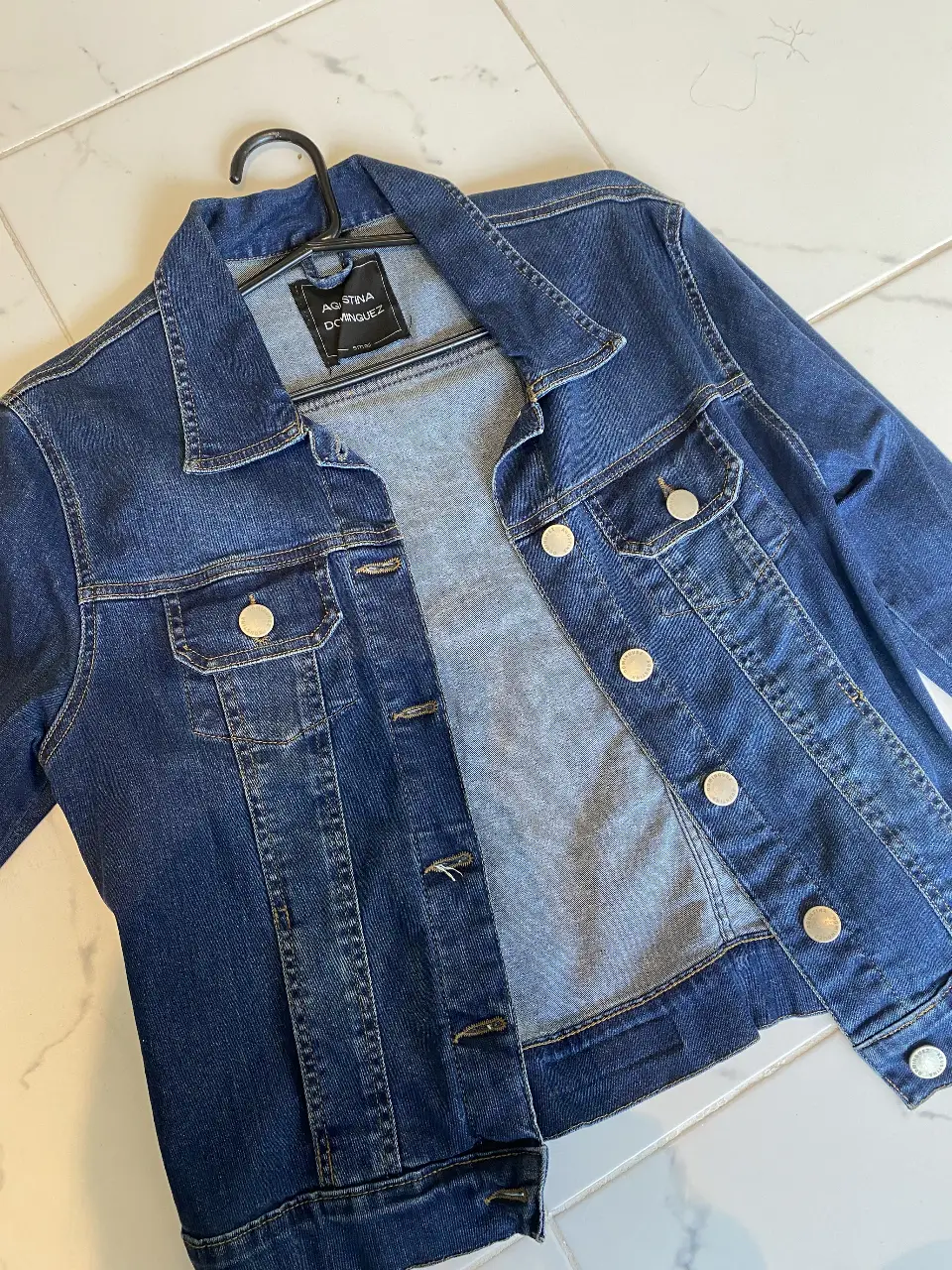 Campera de jean azul oscuro de la marca Agustina Dominguez, con botones plateados y bolsillos. Ideal para un look casual y moderno.