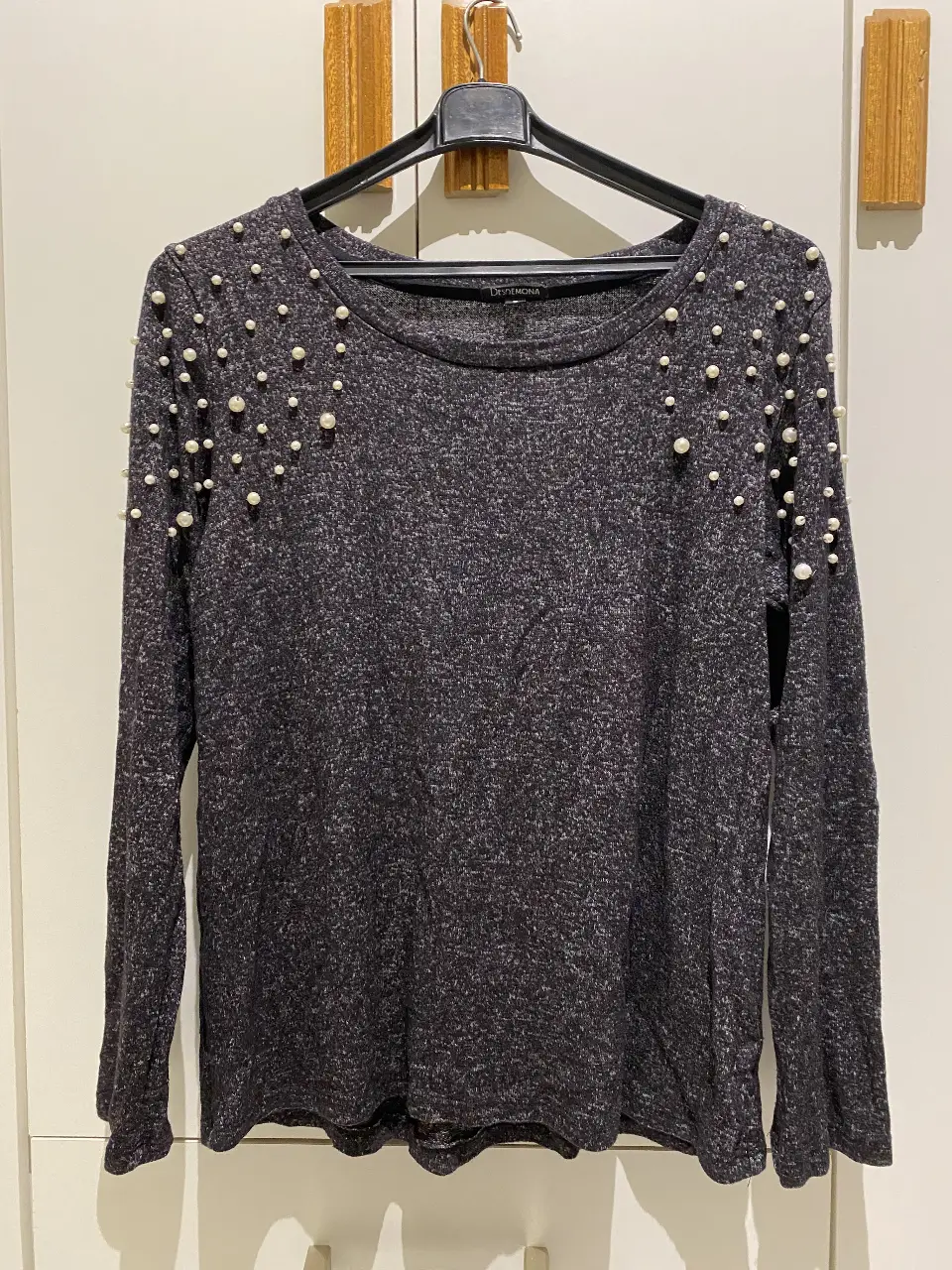 Sweater de manga larga gris oscuro medio azulado con detalles de perlas en los hombros. Ideal para un look elegante y sofisticado.
