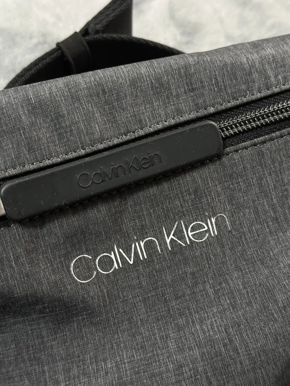 Riñonera Calvin Klein gris, ideal para llevar tus esenciales con estilo y comodidad. Confeccionada en material resistente, cuenta con un compartimento principal y un bolsillo interno para organizar tus pertenencias. El logo de Calvin Klein en la parte frontal le da un toque de sofisticación. Perfecta para un look casual y moderno.