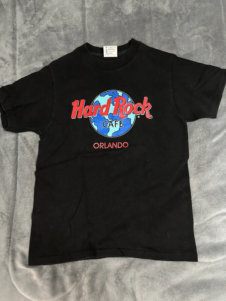 Remera negra de Hard Rock Cafe Orlando, con estampado icónico en el frente. Ideal para un look casual y urbano.