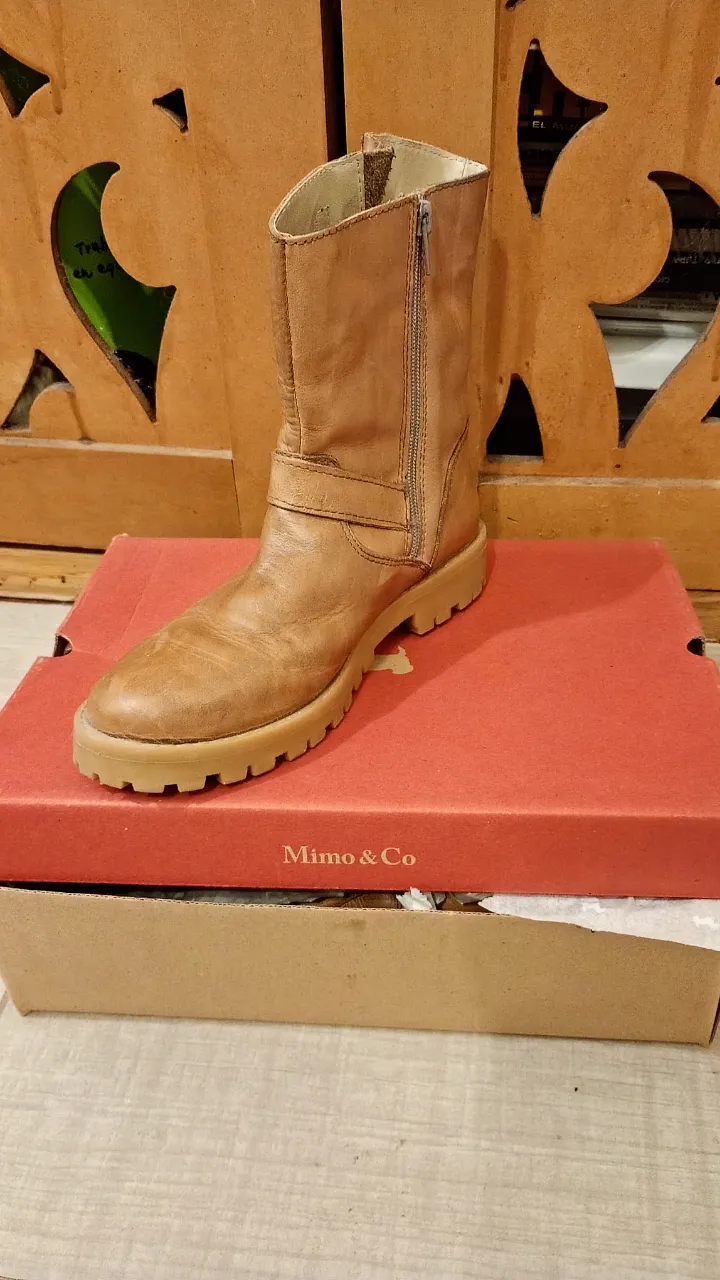 Botas de cuero marrón para mujer, con cierre lateral y detalles de hebilla. Ideales para un look casual y cómodo.