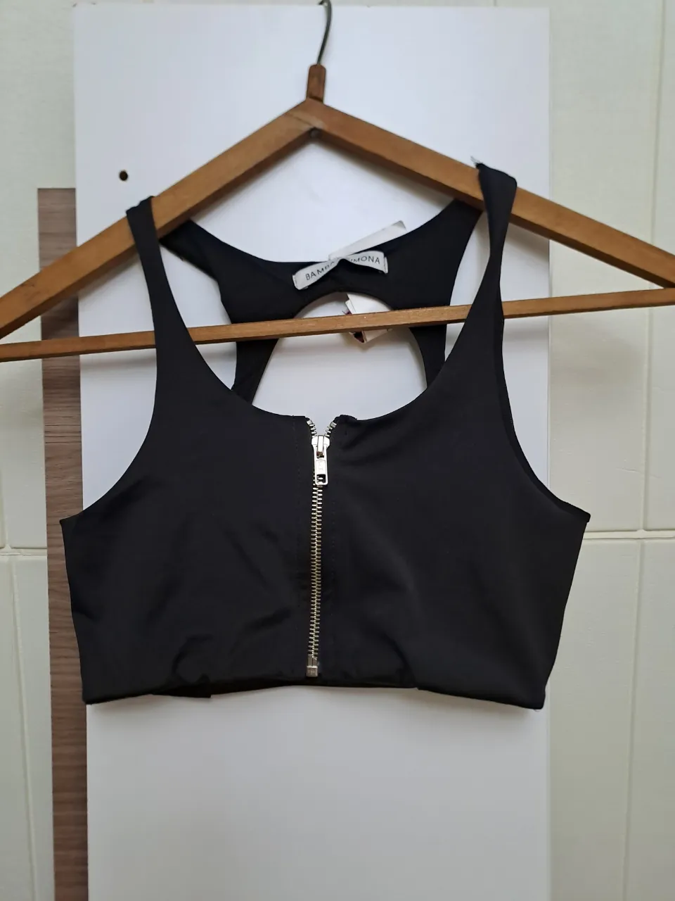 Top negro con cierre metálico al frente y espalda descubierta con recorte.
