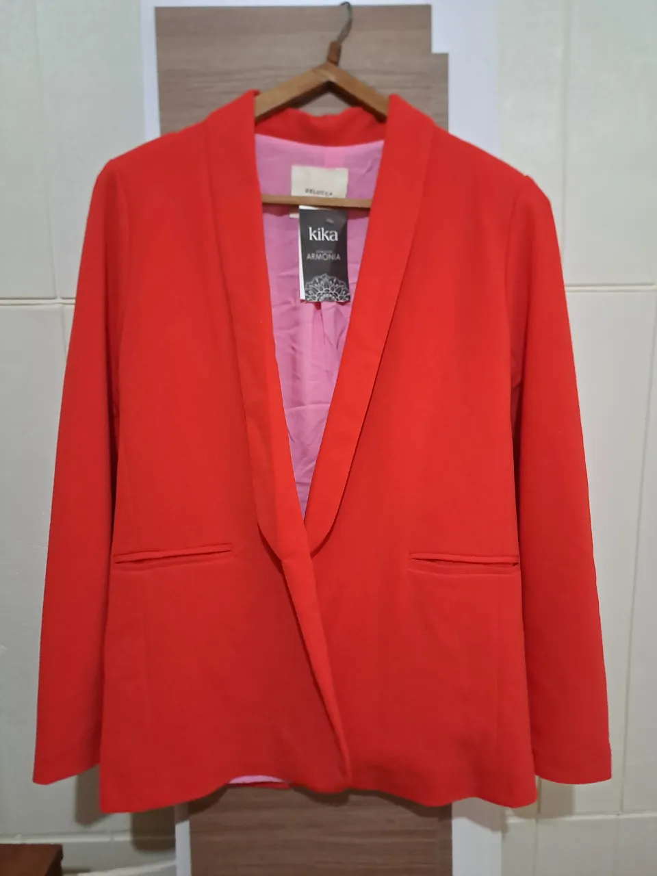 Blazer rojo con solapas y bolsillos frontales. Interior forrado en color rosa.