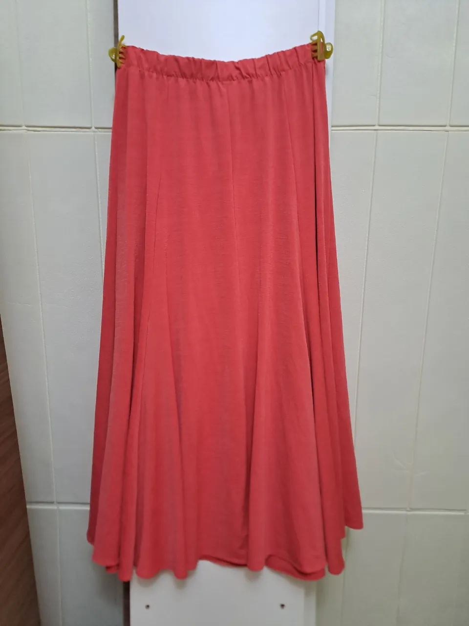 Pollera larga de color salmón con cintura elastizada. La tela tiene una textura sutil. queda para talle s y m, se amolda bien